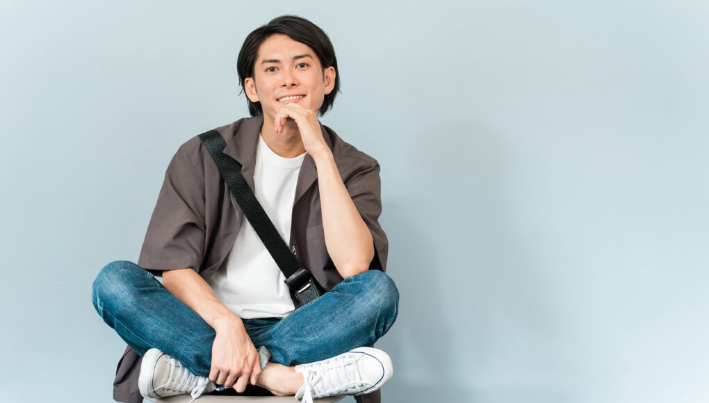 シャツと肩掛けバッグの男性